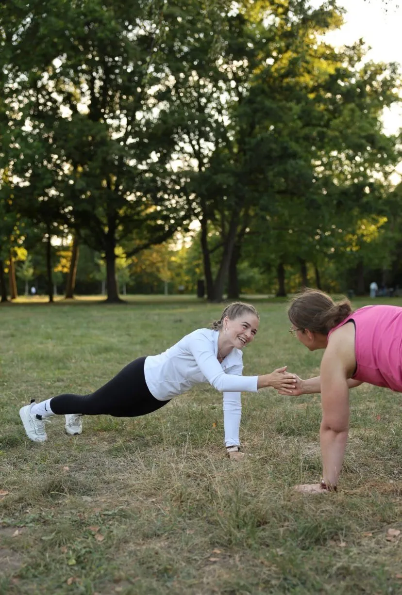 Jessica Bülow and a client in a plank, clapping hands
